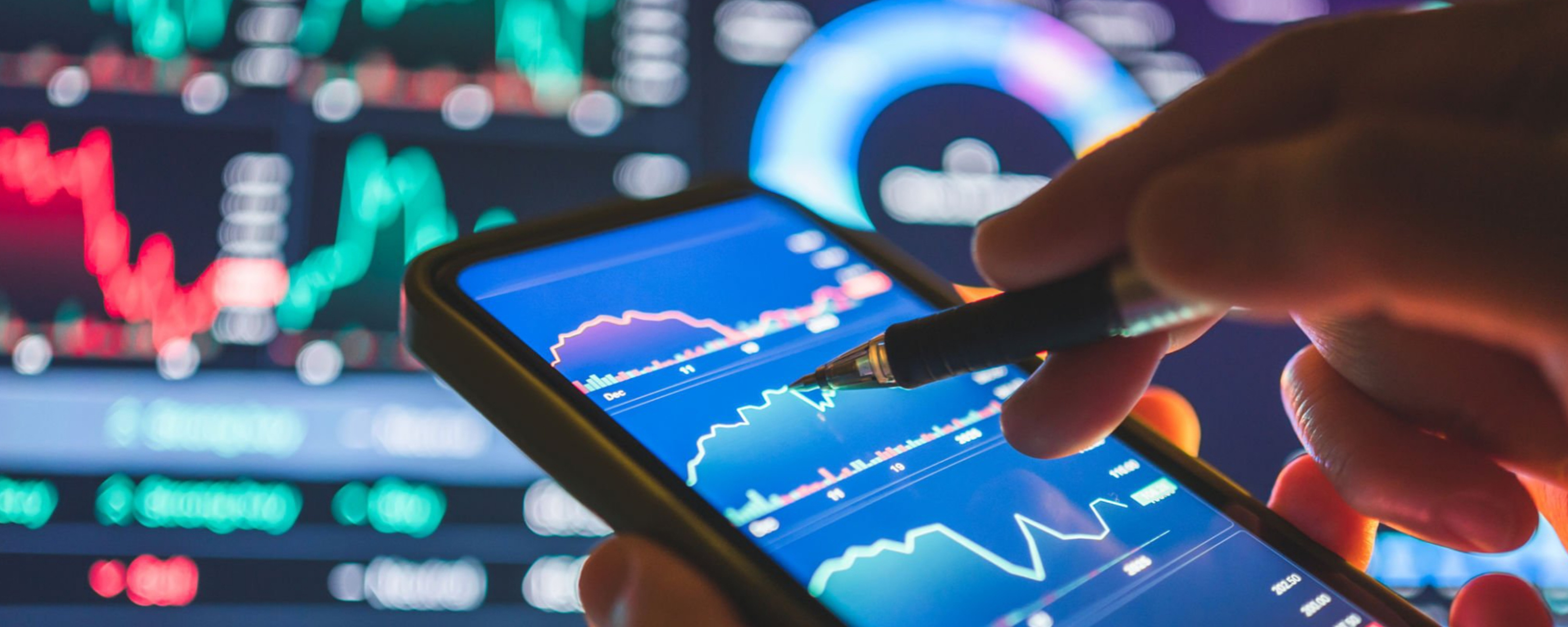 Analyzing financial data on a smartphone, with charts and graphs in the background von primeimages