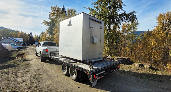 A truck towing a large white box AI-generated content may be incorrect.