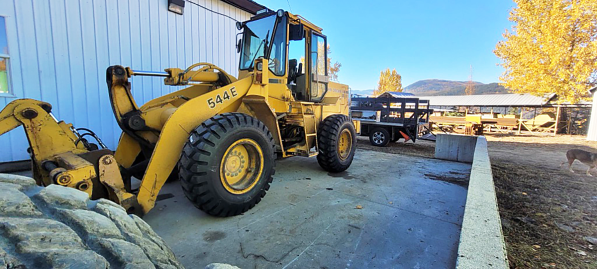 A yellow tractor parked in front of a building AI-generated content may be incorrect.